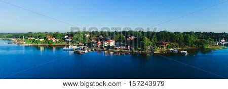 Beautiful super wide-angle aerial view of Stockholm archipelago skerries and suburbs with classic sweden scandinavian designed cottage houses from massive ferryboat