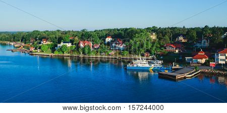 Beautiful super wide-angle aerial view of Stockholm archipelago skerries and suburbs with classic sweden scandinavian designed cottage houses from massive ferryboat