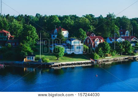 Beautiful super wide-angle aerial view of Stockholm archipelago skerries and suburbs with classic sweden scandinavian designed cottage houses from massive ferryboat