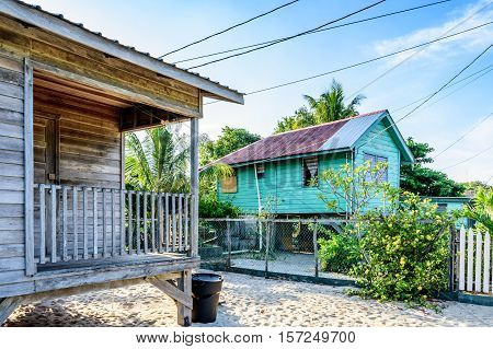 Wooden houses on sand next to Caribbean beach in Belize, Central America
