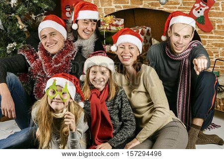 young people will holiday tree in Santa Claus hat happy and cheerful