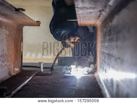 Worker fabricate structure by Shield Metal Arc Welding process