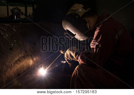 Worker welding repair spare part by SMAW process