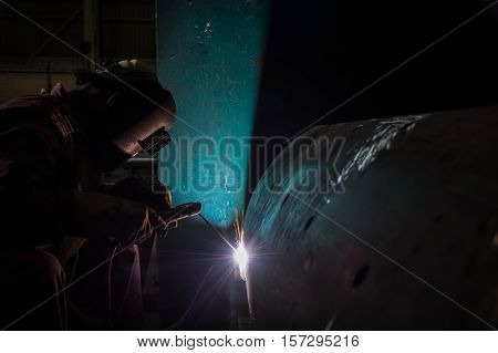 Worker welding repair spare part by SMAW process