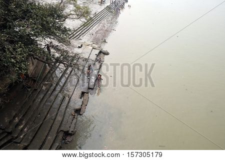 KOLKATA, INDIA - FEBRUARY 10: People bathing in river Hooghly under the busy Howrah bridge in Kolkata on February 10, 2016.