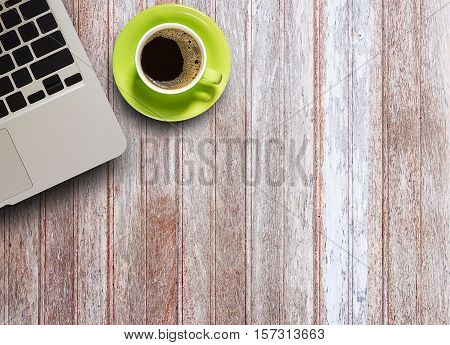 Office table with laptop computer and coffee cup on wood table. View from above with copy space