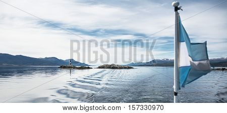 Lighthouse Les eclaireurs in Beagle Channel and blurry Argentina flag