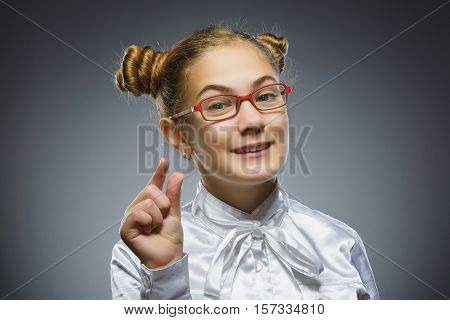 smiling girl. Closeup Portrait of handsome teen in casual shirt show small size isolate on grey background.