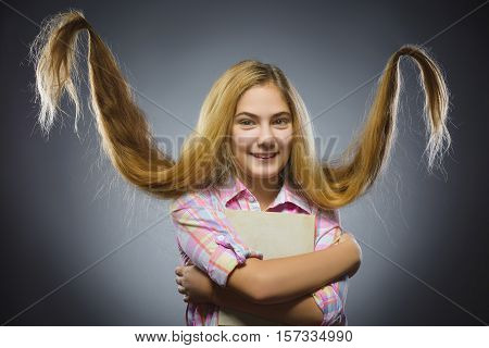 smiling girl with book. Closeup Portrait of handsome teen in casual shirt on grey background. studies concept.