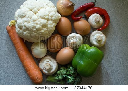 fresh vegetables onions karfiol broccoli mushrooms peppers and eggs on the table