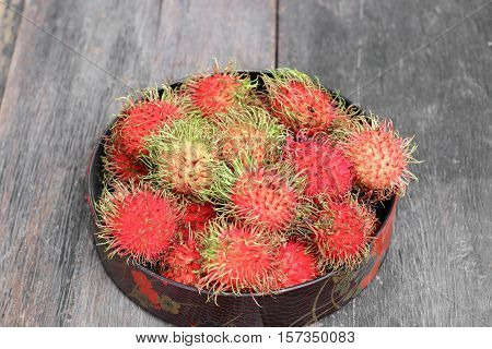 rambutan sweet fruit fresh in plate on wood background :Select focus with shallow depth of field.