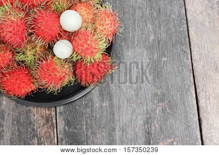 rambutan sweet fruit fresh in plate on wood background :Select focus with shallow depth of field.