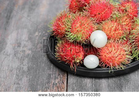 rambutan sweet fruit fresh in plate on wood background :Select focus with shallow depth of field.
