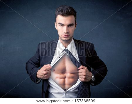 Businessman tearing off his shirt and showing mucular body concept on background