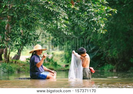 Penampang,Sabah-Oct 29,2016:Kadazandusun father teach his kid how to throwing fishing net at Penampang,Sabah,Borneo.Kadazandusun are traditional farmers cultivating paddy rice & catching fishing