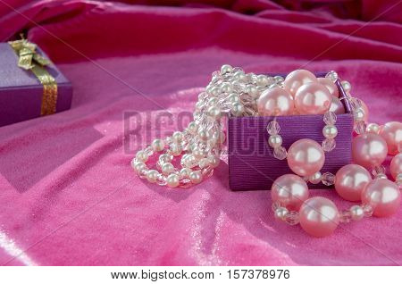 From The Purple Boxes Hanging Pink Pearl Strands Closeup  Из лиловой коробки висят розовые жемчужные