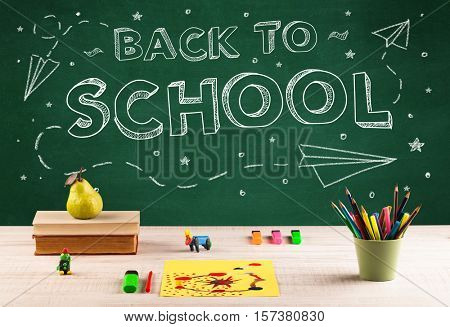 Back to school concepty with writing on blackboard and desk, apple, books, items