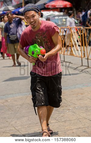 Bangkok, Thailand - April 13, 2008 : 
During Songkran the Thai New Year's festival. A young man with a water gun.