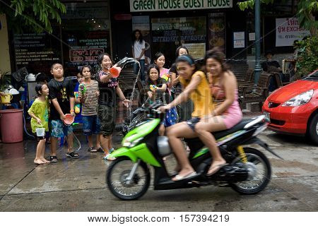 Bangkok, Thailand - April 13, 2008 : 
During Songkran the Thai New Year's festival. Teenagers watering passers-by on the street.