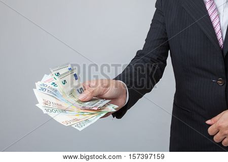 Business Man Displaying a Spread of Cash over isolated a white background
