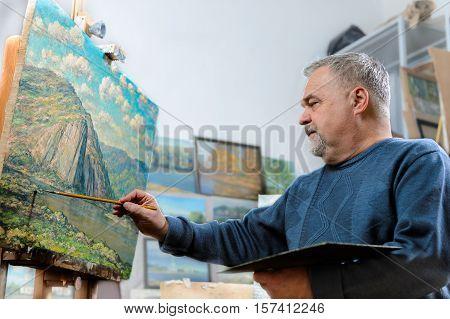 Artist Paints Oil Painting With A Brush And Palette