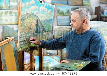 Artist Paints Oil Painting With A Brush And Palette