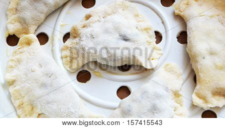 hired by dough dumplings on a white tank steamers