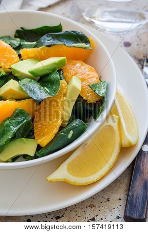 Asian style healthy spinach avocado and orange salad with ginger-vinegar dressing vertical