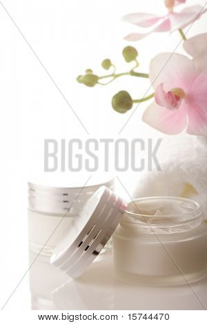 hrnec hydratační krém na obličej a krásné květy orchidejí
