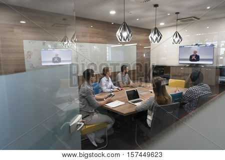 start up business people group attending videoconference call with senior investitior at modern office