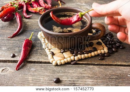 black coffee with pepper spicy. wooden background.