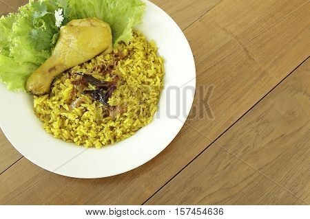 Yellow chicken Biryani Islamic delicious food on wooden floor