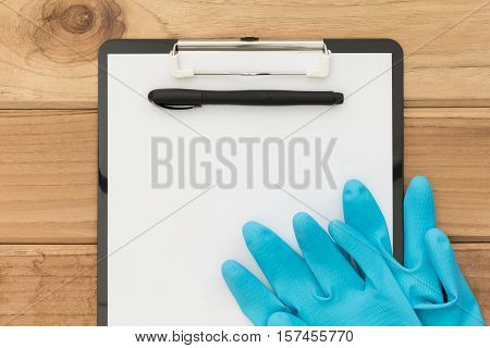 cleaning check list with blue glove on wood table