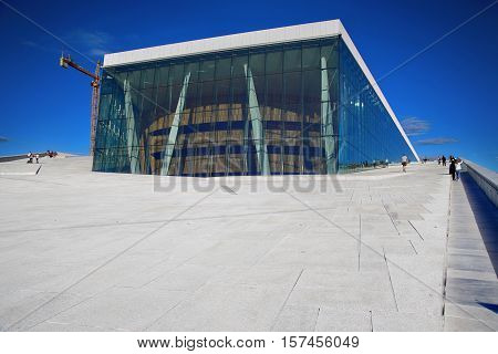 OSLO NORWAY - AUGUST 17 2016: Tourist on the Oslo Opera House which is home of Norwegian National Opera and Ballet and National Opera Theatre in Oslo Norway on August 172016.