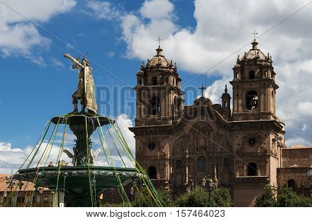 View of the statue of the Inca Emperor with the Church of the Compania de Jesus on the back in Cuzco Peru