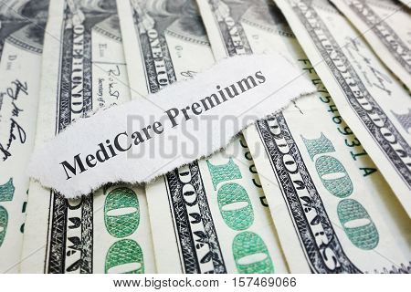 Closeup of Medicare Premiums newspaper headline on cash