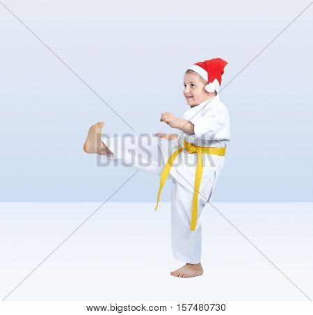 Little athlete beats kicking on the light background