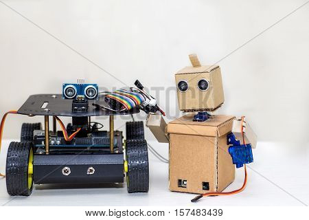 two robots are standing on the white table. Artificial Intelligence