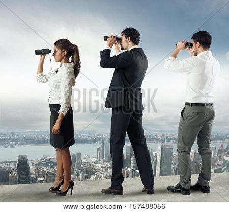 Business people looks at the city from the roof with binoculars