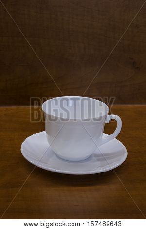 Porcelan cup on the brown table, background
