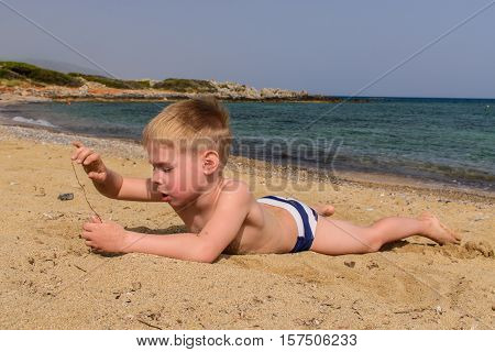 A boy playing on the seashore. 
Family holiday.