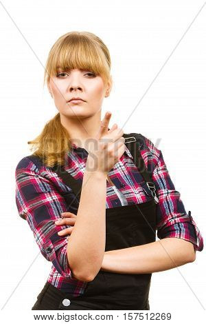 Gardening fahion concept. Attractive woman in pink check shirt and dungarees pointing at something angry face expression. Isolated background