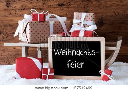 Chalkboard With German Text Weihnachtsfeier Means Christmas Party. Sled With Christmas And Winter Decoration. Gifts And Presents On Snow With Wooden Background.