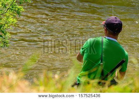 Fisherman fishing in a river rapid, sport fishing, outdoor activities.