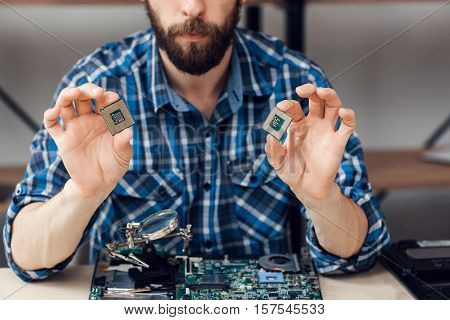 Engineer shows computer microchips. Electronic repair shop, laptop disassembling, technology fixing concept
