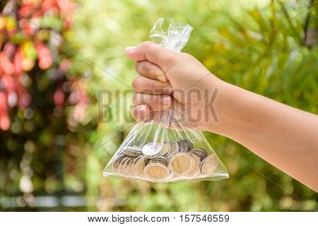 Woman holding a bag of coins in hand