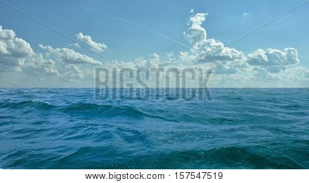 Summer day in the ocean with a cloudy sky.