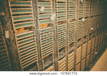 Color image of an old telephone exchange wit many wires.