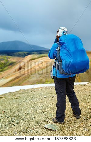 woman hiker photographer taking picture on the rhyolite mountains background in Iceland