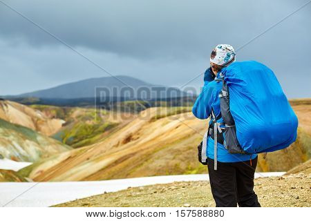 woman hiker photographer taking picture on the rhyolite mountains background in Iceland